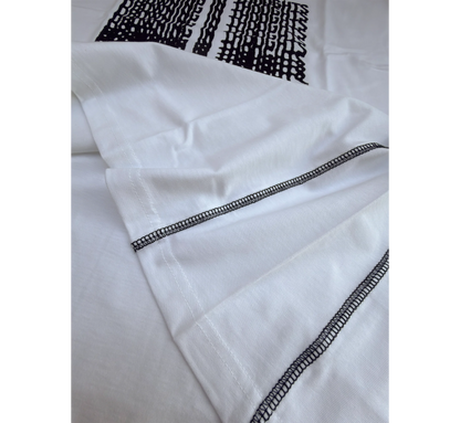 Close-up of white t-shirt side seams and black graphic design
