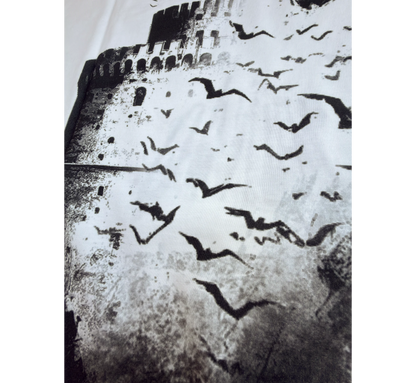 Black and white pattern of birds flying over a the white tower of Thessaloniki.